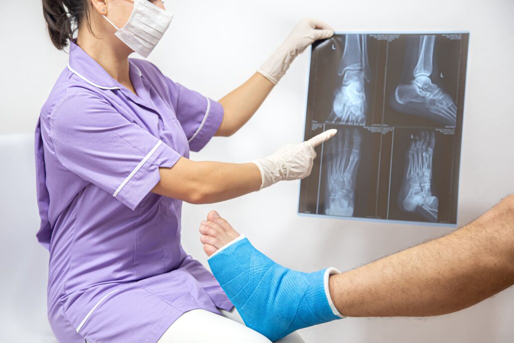 Traumatólogo revisando una radiografía en una sala de consulta médica.